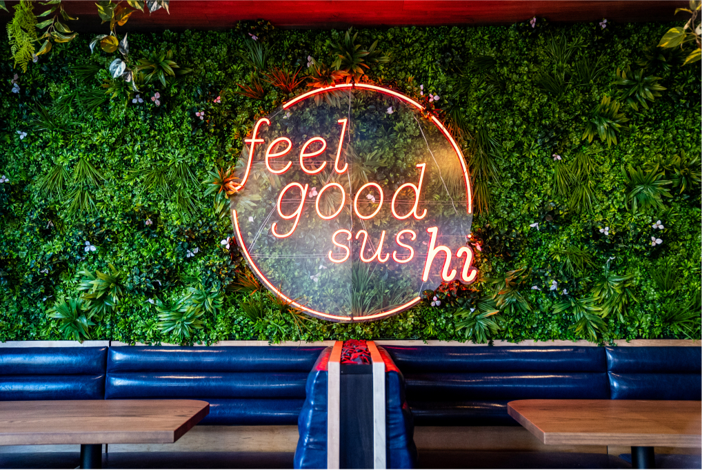 Neon feel good sushi sign on a wall inside of Blue Sushi Sake Grill.