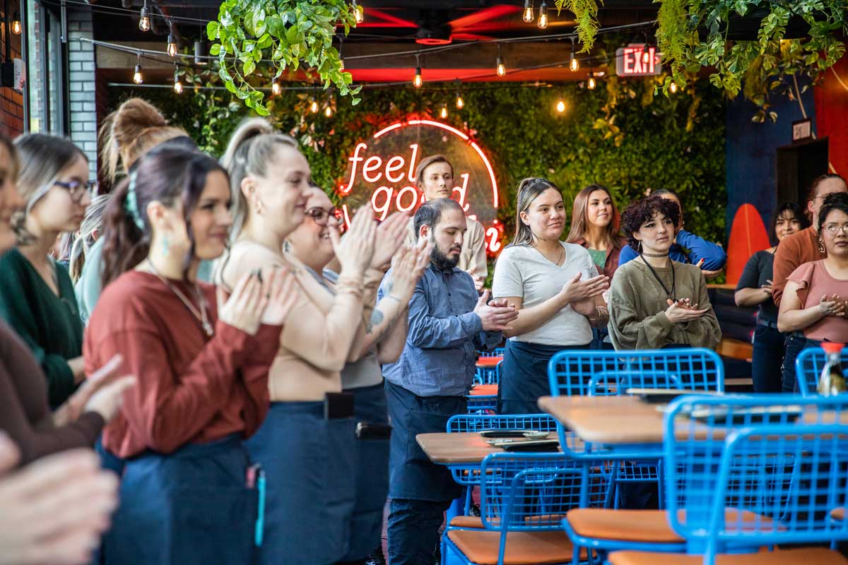 Blue Sushi employees gathered together celebrating accomplishments. 